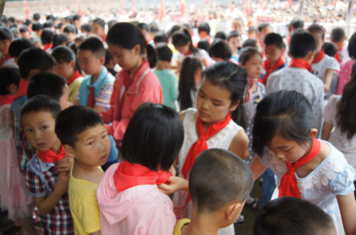 老队员为新队员戴红领巾